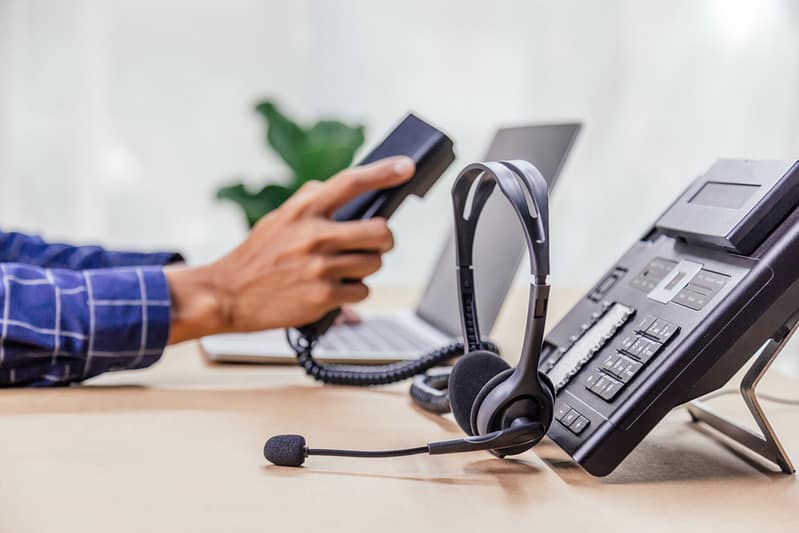 Communication support, call center and customer service help desk. telephone devices with VOIP headset in office.Customer service support (call center) concept.